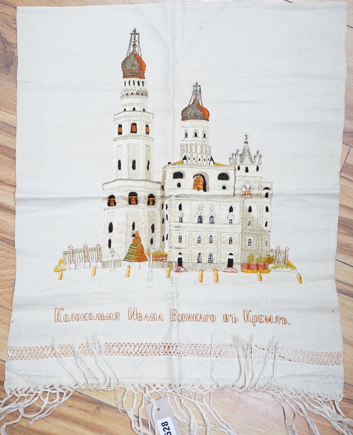 A Russian silk embroidery of a building with embroidered text below: translation ‘Ivan the Greats Belltower, The Kremlin’, 56cm high not including fringe